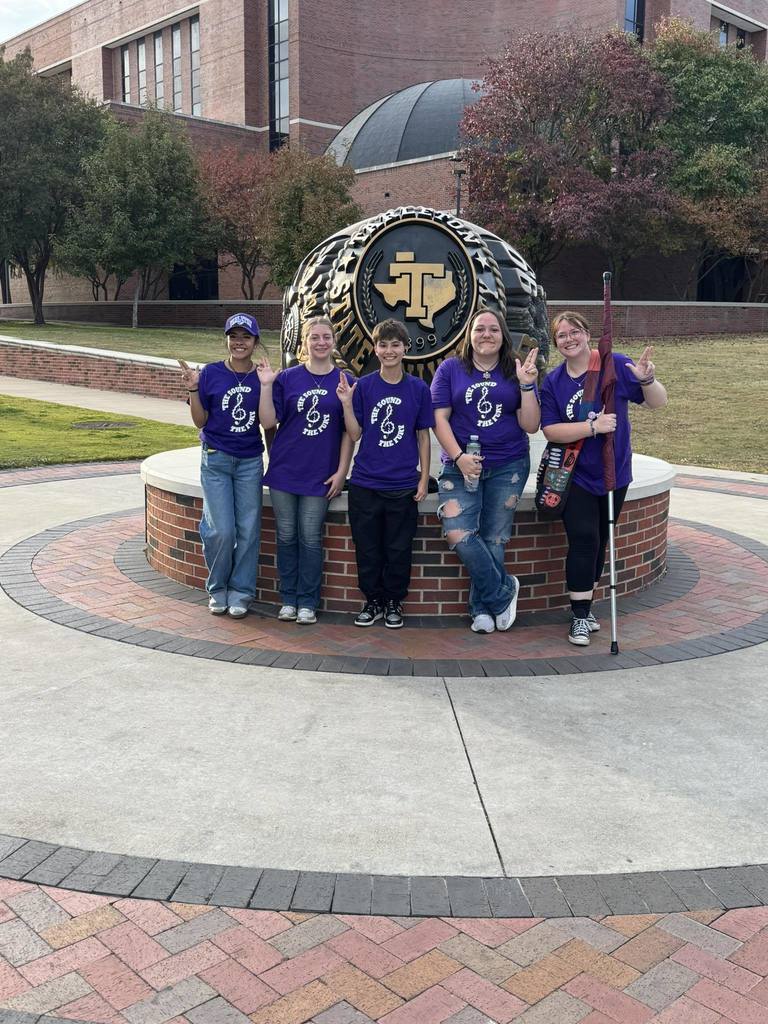 high school band members in front of tarleton state ring statue