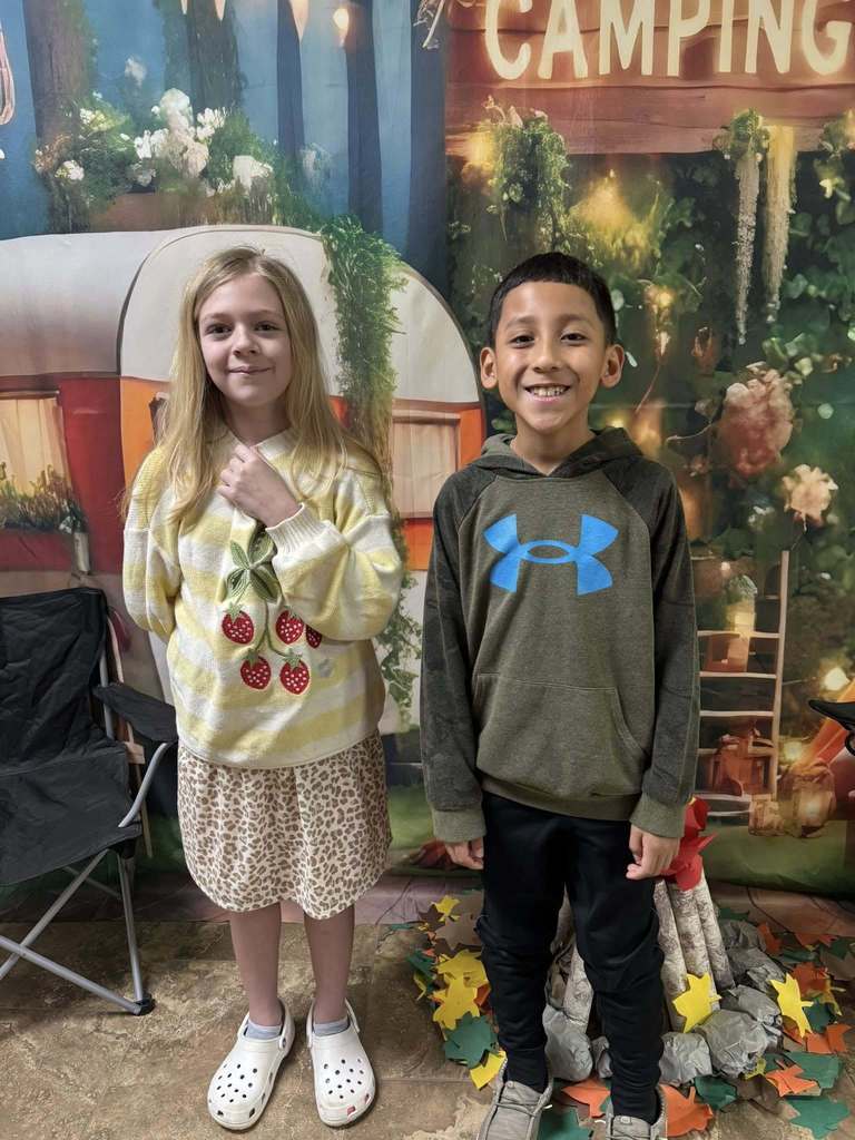 two happy campers of the week standing in front of camping backdrop