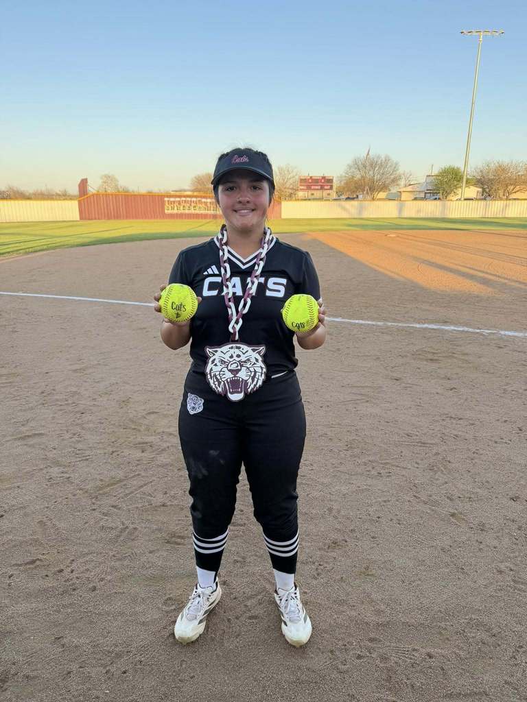 softball player holding two homerun softballs