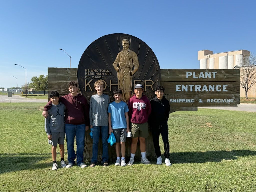 six 8th graders standing in front of kohler plant entrance