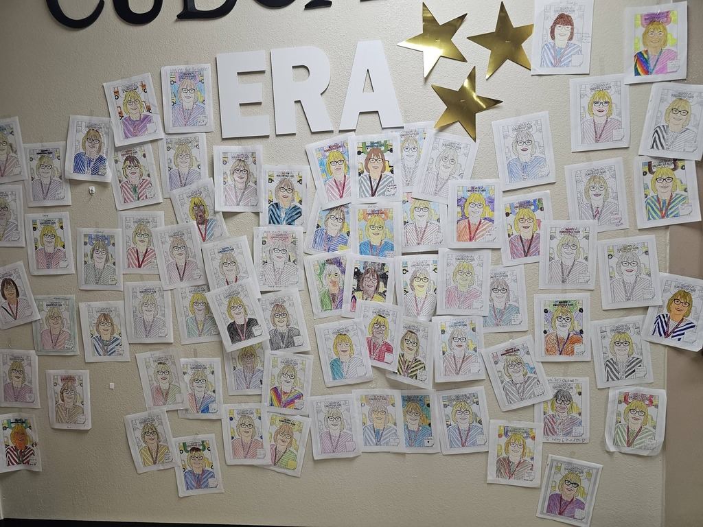 wall of printouts of principal colored by middle school students