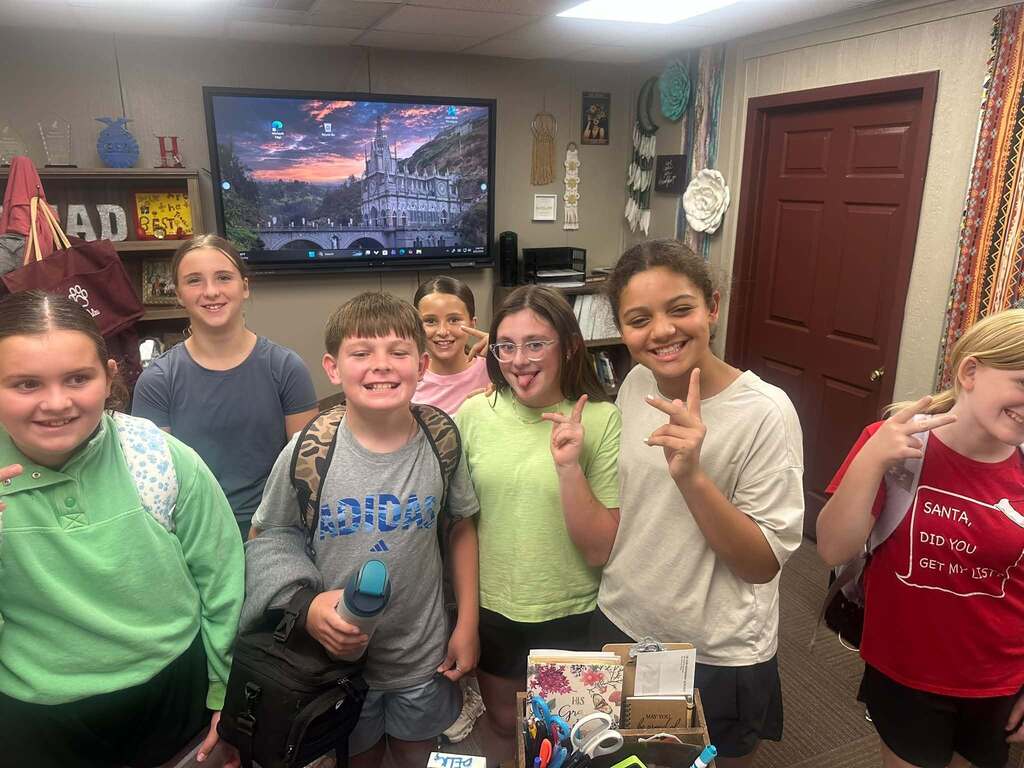 seven middle school students standing in principal's office posing for picture