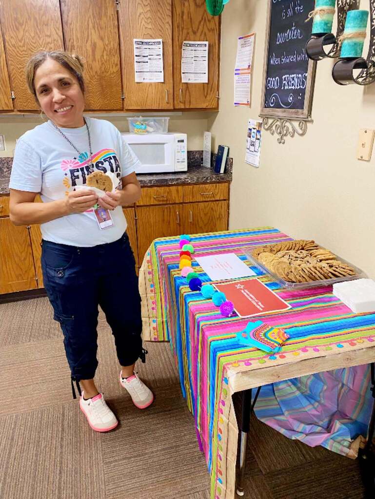 elementary staff member standing next to cookie tray on a table in breakroom