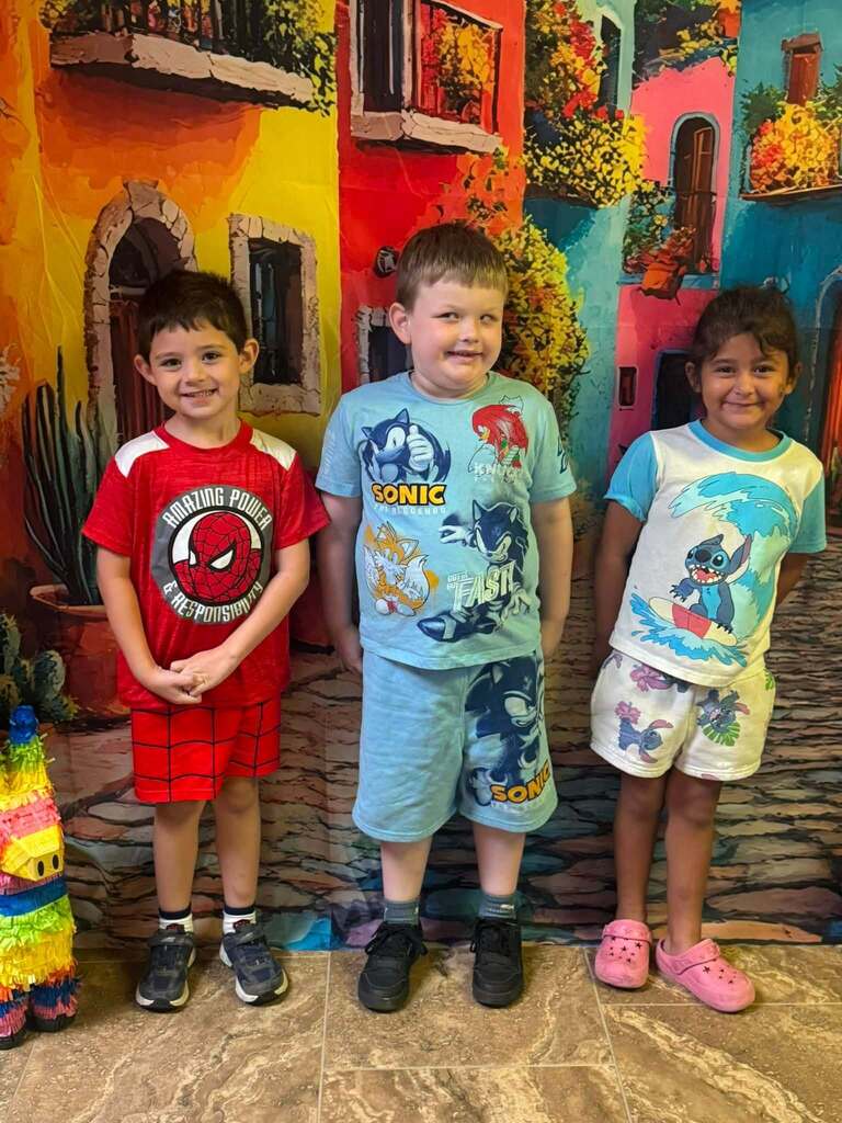 three star students of the week standing in front of decorative backdrop