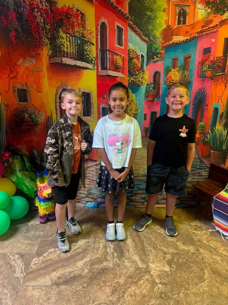 three star students of the week standing in front of decorative backdrop