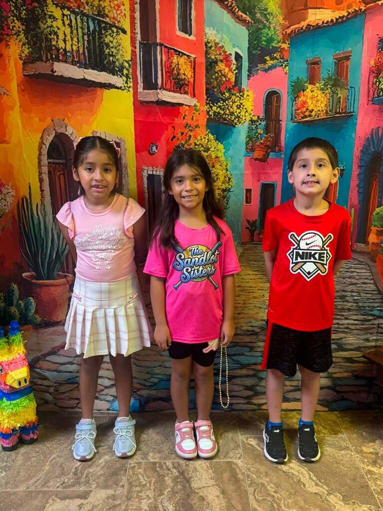 three star students of the week standing in front of decorative backdrop