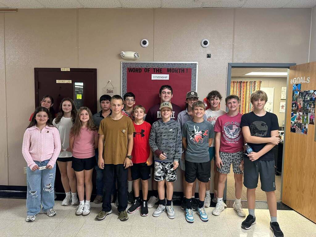 15 students who were chosen as this week's citizenship focus standing in hallway