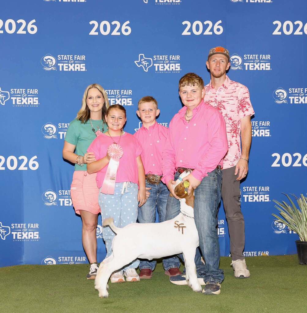 FFA student standing with show animal and family