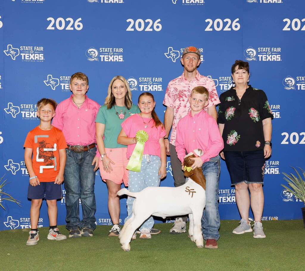 FFA student standing with show animal and family members