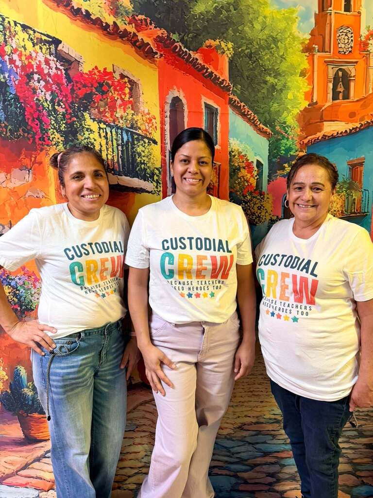 three custodians standing in front of colorful backdrop