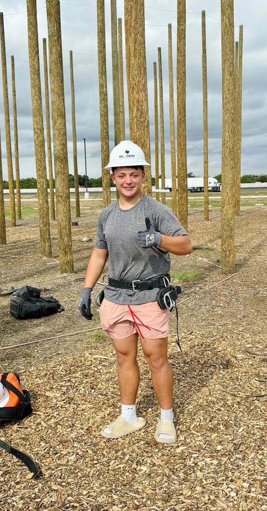 student wearing hard hat giving the thumbs up