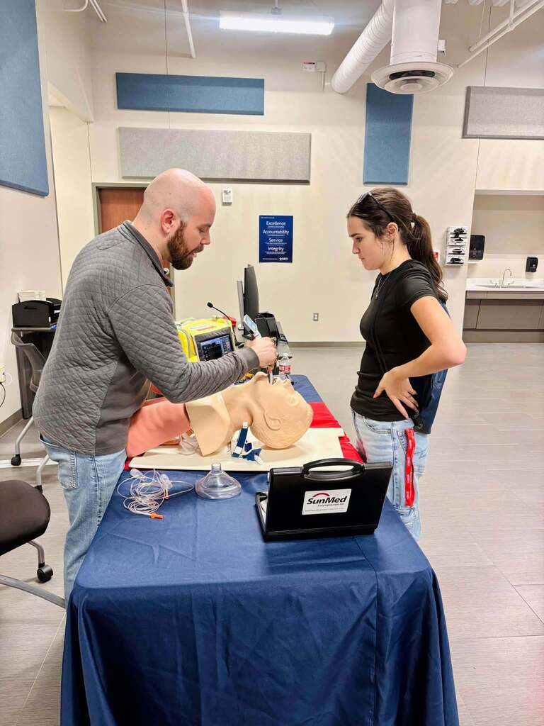instructor showing student medical technique on dummy