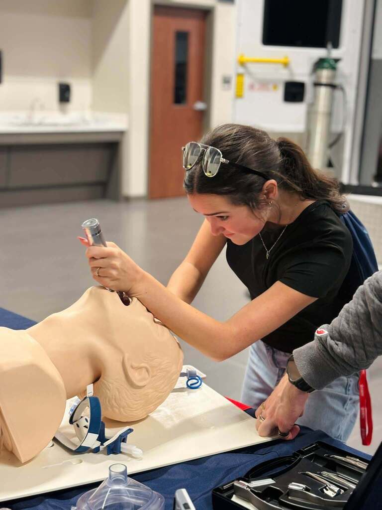 student practicing medical training on dummy