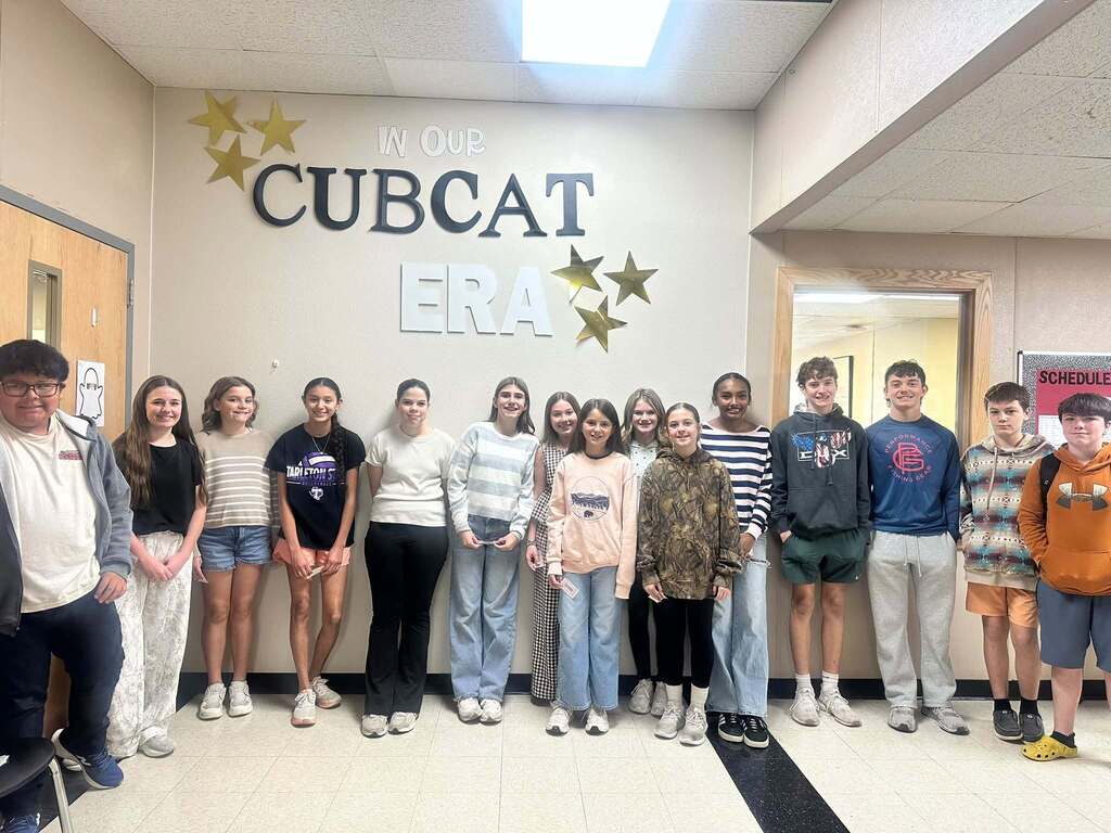 students of the week gathered along hallway wall