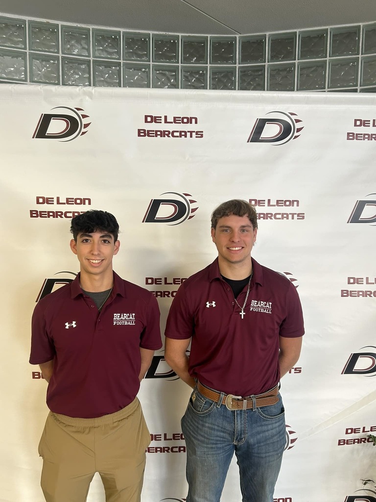 two football players standing in front of de leon backdrop