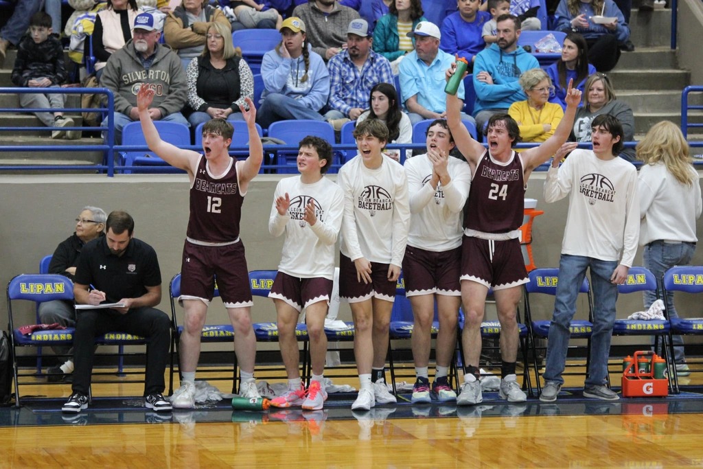 bball team up in arms cheering along bench