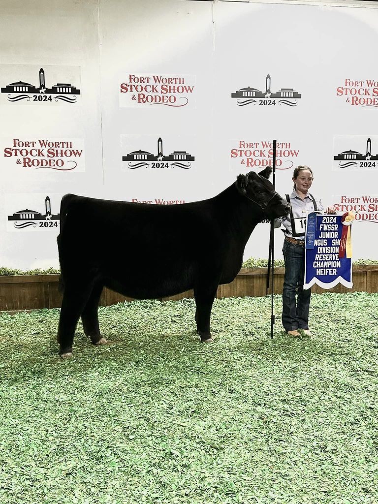 young student posing with cow