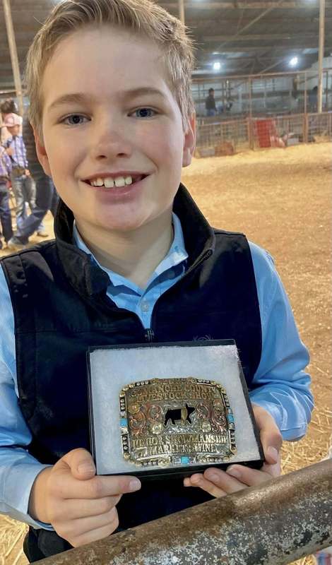 young ffa member holding his belt buckle