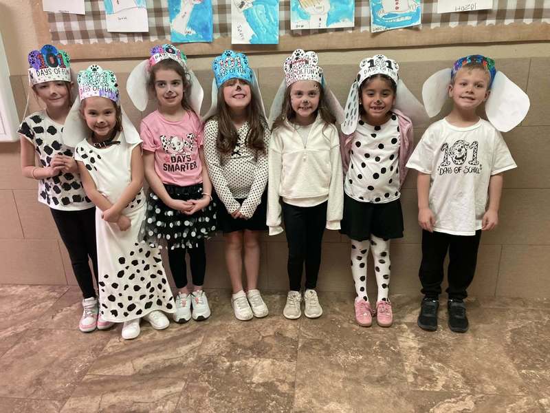 seven student dalmations standing next to wall