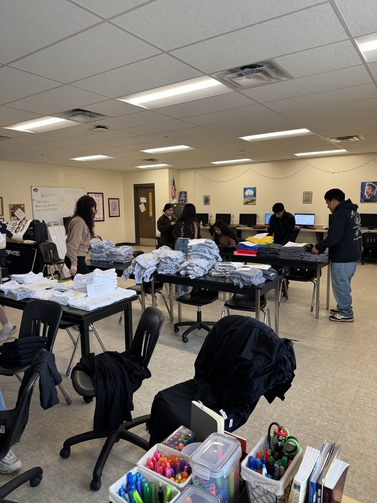 Leopard Den students folding shirts
