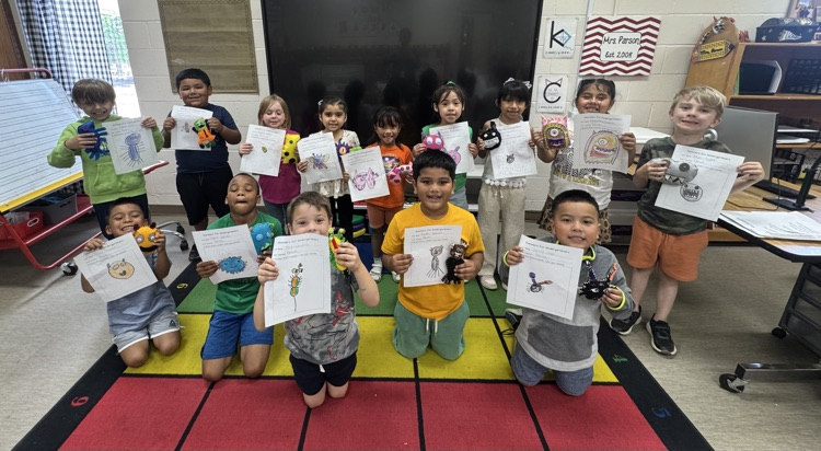 group picture of kindergarten students holding their monsters