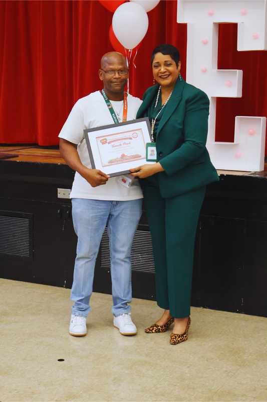 Image of Dr. Yvette Evans and Kinneth Priest as he receives the February Hero Perk Award