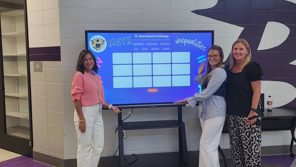 BMS 8th grade teachers standing with their Canva AI created Math Game for the 2025 Math and Science Curriculum Night