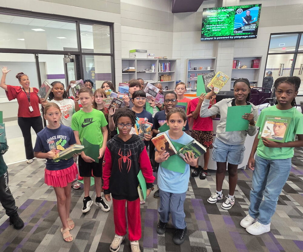6th Grade Students show the books they checked out. 