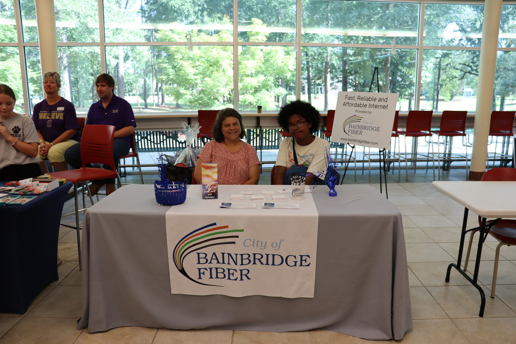 City of Bainbridge Fiber representatives sit behind an informational table display.