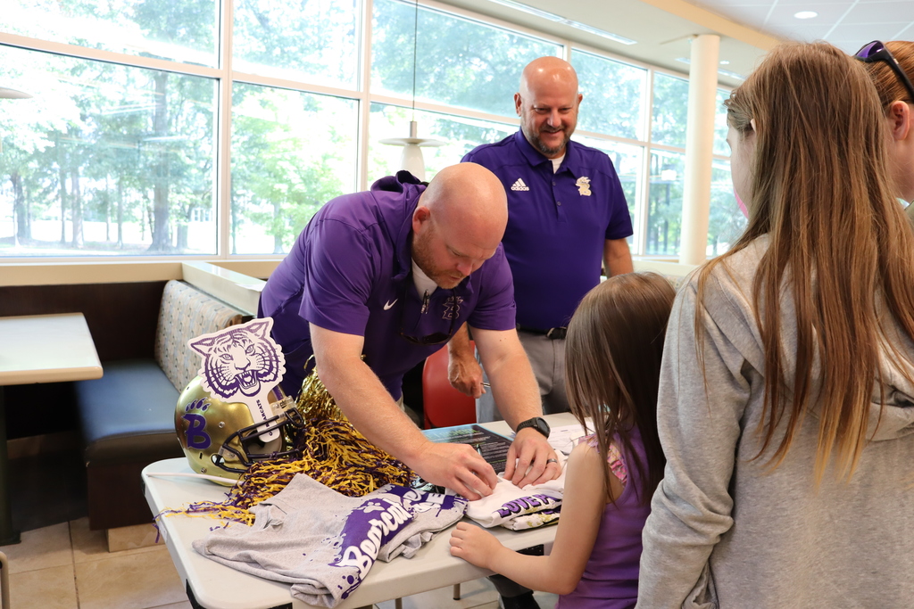 bearcat staff member selects size from pile of t shirts for little girl