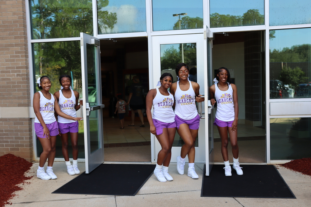 Bearcat cheerleaders greet attendees at the entrance with welcoming smiles.