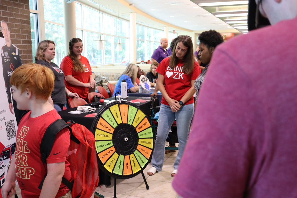 Bank OZK representatives engage with families at a spinning prize wheel station.