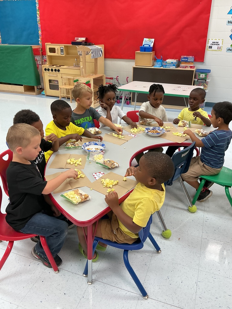 Students at tables making trail mix.