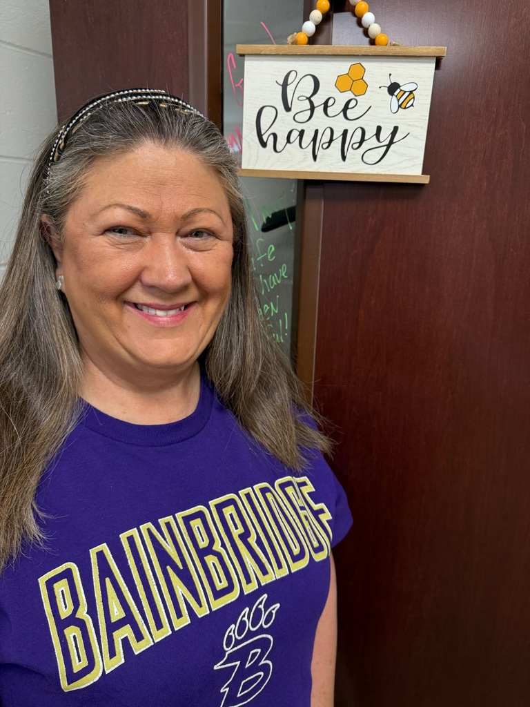 Portrait of an individual wearing spirited purple and gold Bearcat attire. The background varies, including office and home settings with decorative and school-related items visible.