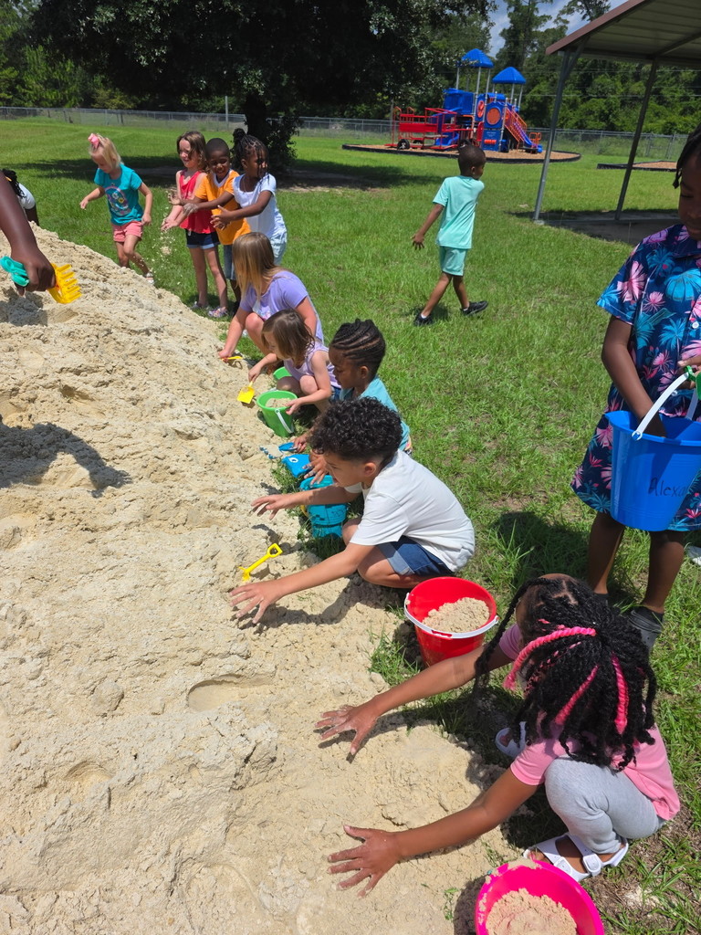 Students playing in the sand.