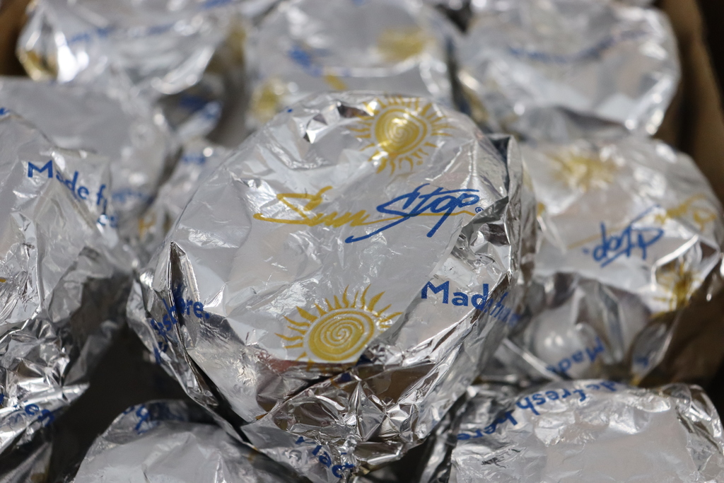 Close-up photo of wrapped SunStop breakfast biscuits with the SunStop logo and sunshine design printed on the foil.