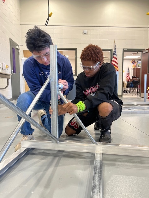 Mr. Cole's students helping to build desks for the school.