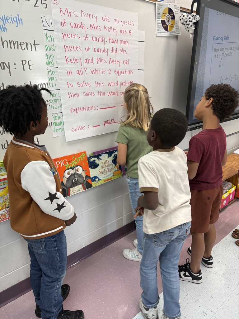 4 students working at a white board