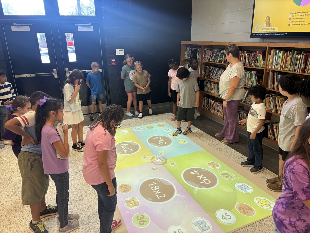 This image contains pictures of kids playing a math game on the active floor.
