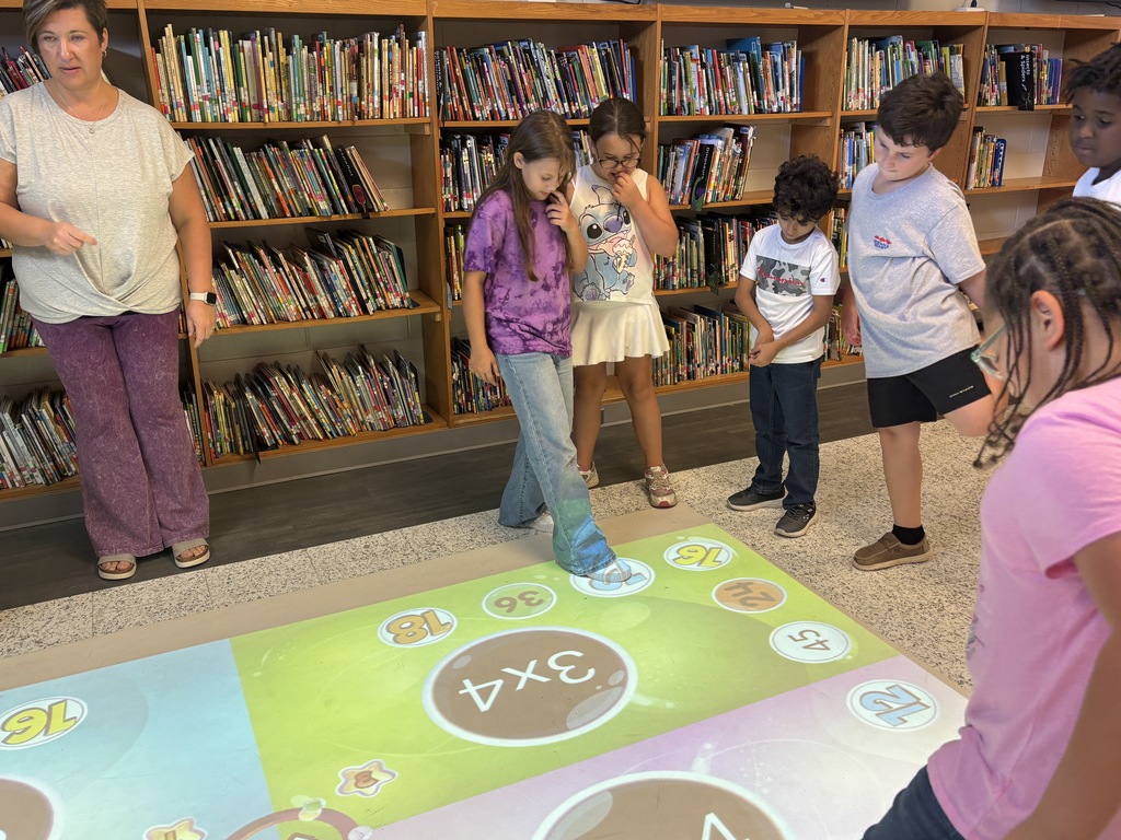This image contains pictures of kids playing a math game on the active floor.
