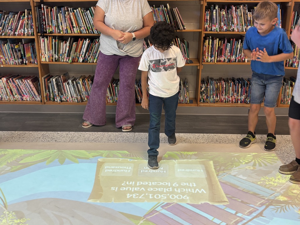 This image contains pictures of kids playing a math game on the active floor.