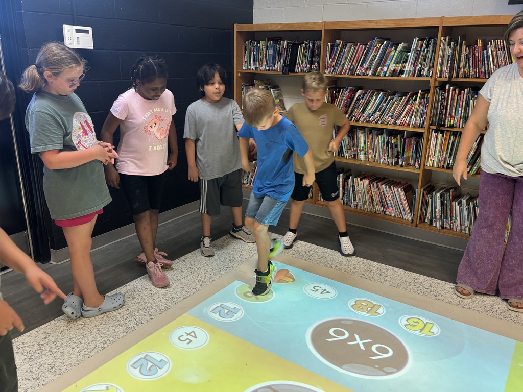 This image contains pictures of kids playing a math game on the active floor.