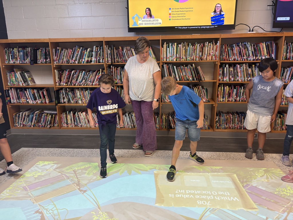 This image contains pictures of kids playing a math game on the active floor.