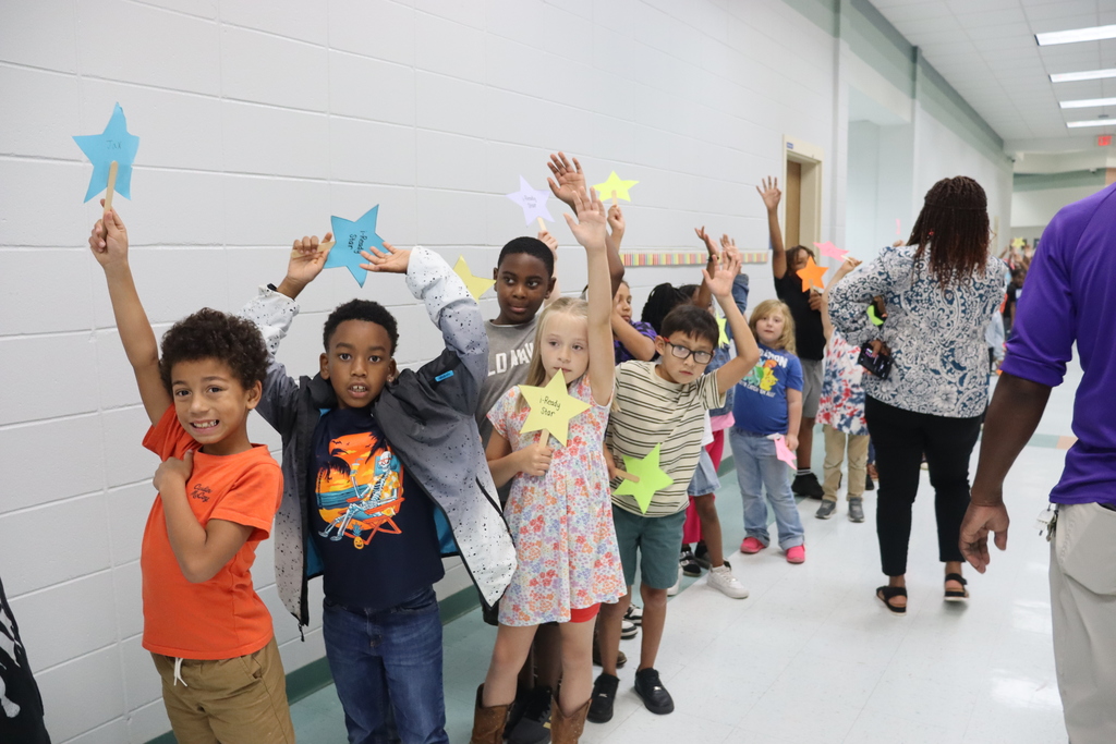 Students in hallway raise their self crafted iready stars excitied 