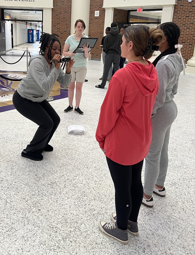 Student filming a pedestal shot of two students.