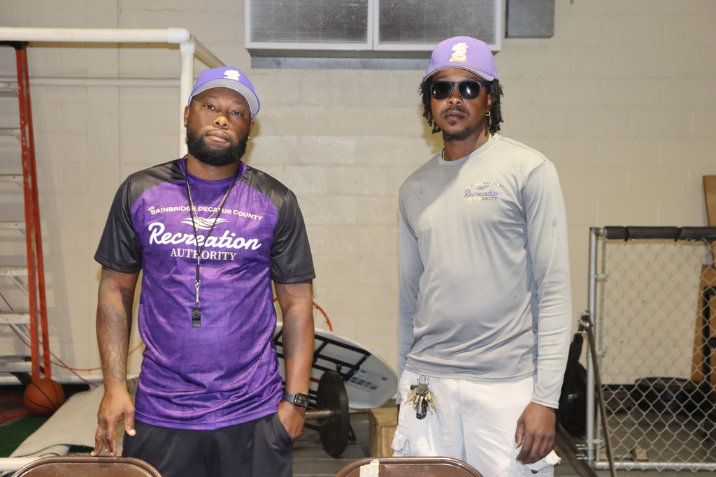 Two staff members from the Bainbridge-Decatur County Recreation Authority pose together in matching purple and gray uniforms.