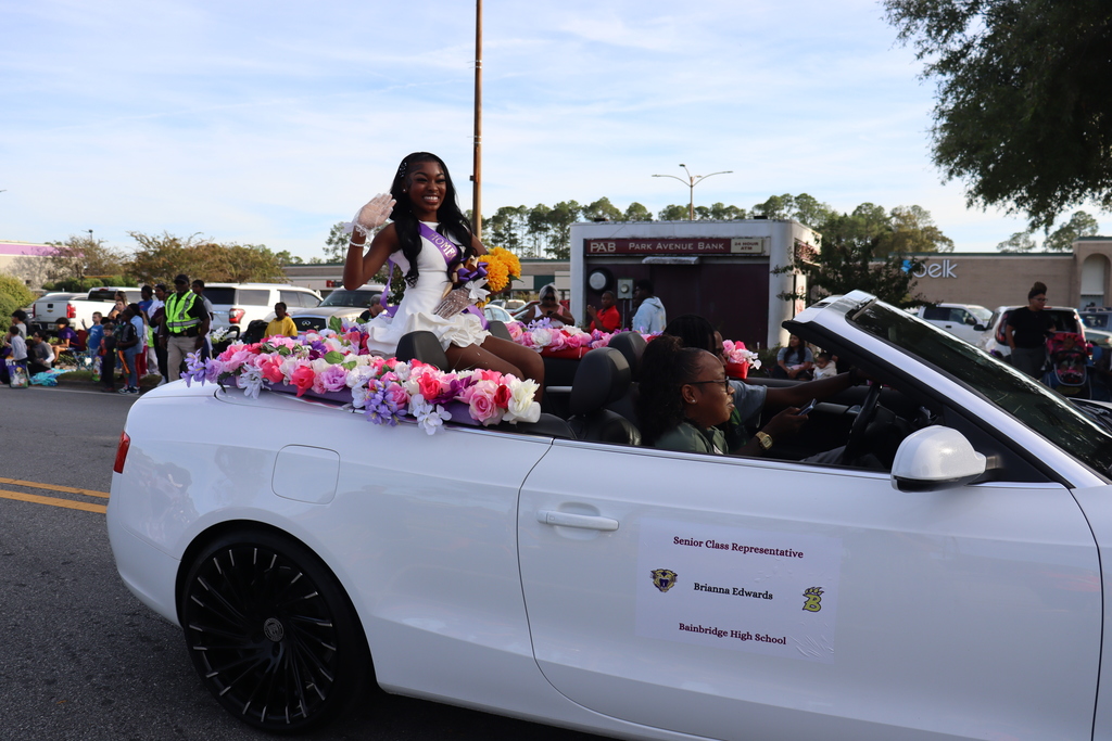 Bainbridge High School Senior Class Representative Brianna Edwards waves from a convertible decorated with flowers.