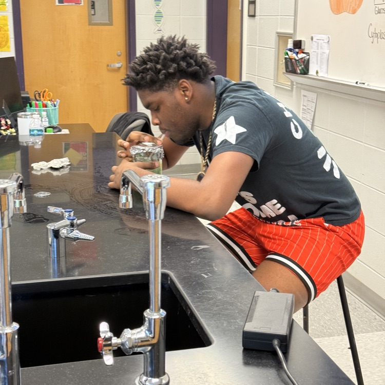 Biology students blew bubbles in a beaker to demonstrate how increased physical activity affects the body’s cellular respiration rate.