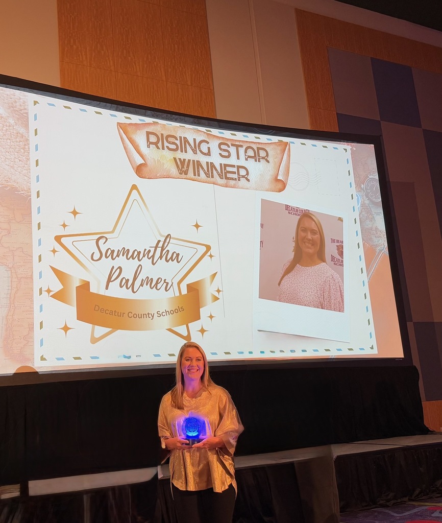 Samantha Palmer stands smiling in front of a large screen displaying “Rising Star Winner – Samantha Palmer, Decatur County Schools,” holding her award.