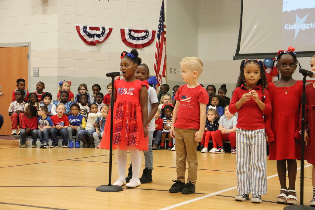 A group of JWP kindergarteners raise their hands and sing during the Veterans Day performance.